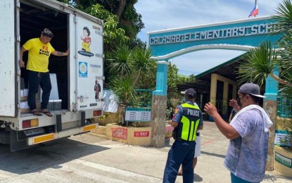 <p><strong>TURNOVER</strong>. Law enforcers provide security coverage as vote counting machines (VCMs) are delivered at the Calayab Elementary School in Laoag City on Wednesday (May 4, 2022. The final testing and sealing of VCMs are set on May 6, provincial election supervisor Joel Gines said on Wednesday.</p>