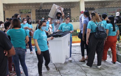 <p><strong>ADDITIONAL HONORARIA.</strong> Members of the Electoral Board and other poll workers carry vote counting machines (VCMs) during the final testing and sealing at the Dr. Jose P. Rizal Elementary School in Barangay Sto. Cristo, Dasmariñas City, Cavite on May 4, 2022. The Commission on Elections is eyeing to give additional honoraria to electoral board members who rendered overtime work during the May 9 elections due to faulty VCMs. <em>(PNA photo by Gil Calinga)</em></p>