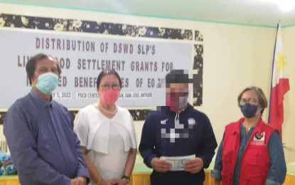 <p><strong>LIVELIHOOD GRANT</strong>. A former rebel in the province of Antique receives his livelihood settlement grant from Antique Provincial Social Welfare and Development Officer Lazaro Petinglay and Peace and Order and Public Safety consultant Margie Gadian (1st and 2nd from left) and the Department of Social Welfare and Development Sustainable Livelihood Program Antique program coordinator Geralyn Flores (right) in San Jose de Buenavista on Thursday (May 5, 2022). Flores said they released the cash grant in the amount of PHP20, 000 to each former rebel as capital for their livelihood. <em>(PNA photo by Annabel Consuelo J. Petinglay)</em></p>