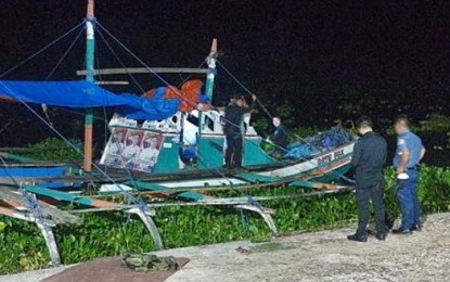 <p><strong>GRENADE ATTACK.</strong> Policemen inspect the fishing boat moored at Tamontaka river in Barangay Kalanganan 2, Cotabato City, that was damaged on May 4, 2022 by a grenade blast. Nobody was hurt in the incident.<em> (Photo courtesy of the 6th Infantry Division)</em></p>