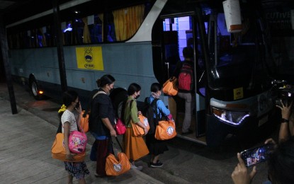 <p><strong>TRAVEL TO SAMAR.</strong> Beneficiary families of the "Balik Probinsya, Bagong Pag-Asa" program get on a shuttle bus at the BP2 depot in Quezon City on May 5, 2022. Three families composed of 13 individuals are back home in Samar, Northern Samar, and Siquijor. <em>(PNA photo by Robert Oswald P. Alfiler)</em></p>