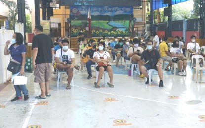<p><strong>ELECTION DAY</strong>. Voters check their names and precinct numbers on the voters’ list at the covered court of the Delfin Geraldez Elementary School, Salvia Street, Barangay Kaligayahan, Novaliches-Fairview, Quezon City on Monday (May 9, 2022). Other voters patiently waited for their turn to vote in the holding area as social distancing was observed as part of the Covid-19 protocols.<em> (PNA photo by Oliver Marquez)</em></p>