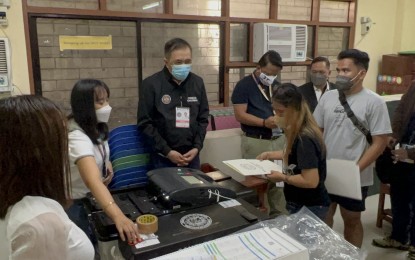 <p><strong>ELECTION DAY</strong>. Comelec chairman Saidamen Pangarungan (wearing black jacket) looks on while a voter feeds her ballot into the vote counting machine in a polling place in Pasay City on Monday (May 9, 2022). Pangarungan said everything is going on smoothly so far. <em>(PNA photo by Ferdinand G. Patinio) </em></p>