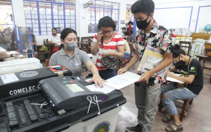 <p><strong>YOUNG VOTER.</strong> A young voter feeds his ballot into the vote-counting machine with assistance at precinct No. 299 at the Bagong Nayon 1 Elementary School, Cogeo, Antipolo City on Monday (May 9, 2022). Some 61 million Filipinos are expected to participate in this year's polls. <em>(PNA photo by Rico H. Borja)</em></p>