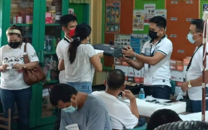 <p><strong>BREAKDOWN</strong>. Technical staff fixing a vote counting machine that malfunctioned at the Kapangian Central School in downtown Tacloban City. Only 22 of the 6,271 vote counting machines (VCMs) have malfunctioned in Eastern Visayas during the voting on Monday (May 9, 2022). <em>(PNA photo by Roel Amazona)</em></p>