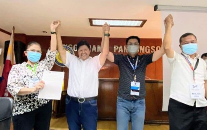 <p><strong>NEW MAYOR</strong>. The electoral board of canvassers raise the hands of Dagupan City's elected Mayor Belen Fernandez (2nd from left) during the proclamation on Tuesday (May 10, 2022). Fernandez won against incumbent Mayor Marc Brian Lim.<em> (Photo courtesy of Belen Fernandez Facebook page)</em></p>