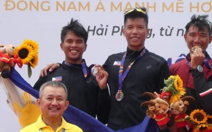 <p>Pvt. Chris Nievarez (right), and his teammate Mr. CJ Jasmin (left), proudly wear their silver medals during the awarding ceremony for the men’s lightweight double sculls (rowing) event of the 31st Southeast Asian Games in Hanoi, Vietnam on Wednesday (May 11, 2022). <em>(Photo courtesy of PA) </em></p>
