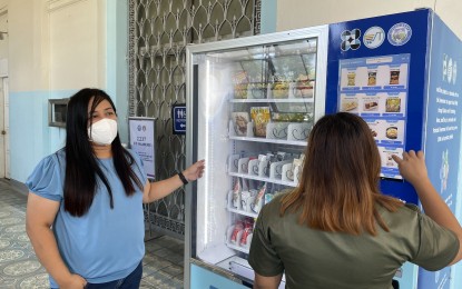 <p><strong>VENDING MACHINE</strong>. A capitol employee buys snacks from the vending machine at the capitol lobby in Laoag City in this undated photo. Elma Gabriel, head of the Micro, Small, and Medium Enterprise Office, said Thursday (May 12, 2022) the vending machine offers a selection of local products.<em> (Photo by Leilanie G. Adriano)</em></p>
