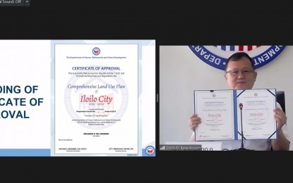 <p><strong>CITY DEV’T</strong>. Department of Human Settlements and Urban Development Secretary Eduardo del Rosario signs the approval of the Iloilo City Comprehensive Land Use Plan (CLUP) 2021-2029 during a virtual ceremony on Thursday (May 12, 2022). The CLUP sets the direction for the development of the city. <em>(Photo courtesy of Iloilo City Government FB page)</em></p>