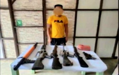<p><strong>SQUAD LEADER</strong>. Cayetano Santos Jr., alias Juning, a squad leader of the New People's Army, and the firearms that he yielded to troops of the 10th Infantry Division (10ID) and police officers. He was captured in Barangay Simulao, Boston, Davao Oriental on May 12, 2022. <em>(Photo courtesy of 701st Infantry Brigade)</em></p>