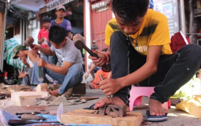 <p><strong>WOODCARVING</strong>. Young people in Ifugao join a woodcarving competition during the Imbayah Festival in Banaue, Ifugao in 2019. In Baguio, the city government has tied up with the Department of Science and Technology-Cordillera and handicraft makers for a PHP1.2-million industry development project that would benefit handicraft shops. <em>(PNA photo courtesy of PIA-CAR)</em></p>
