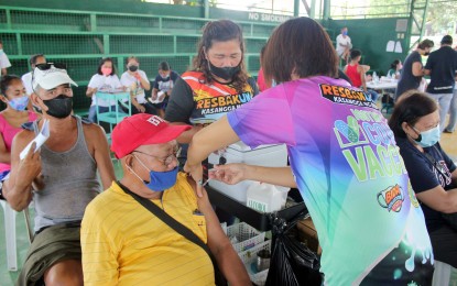 <p><strong>PROTECTED.</strong> Eduardo Peña, 73, receives his first booster shot in Barangay Salitran 3, Dasmariñas City, Cavite on Tuesday (May 17, 2022). The national government has also rolled out the second booster shot for immunocompromised adults and will soon include health care workers and senior citizens. <em>(PNA photo by Gil Calinga)</em></p>