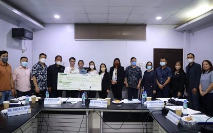 <p><strong>TOPNOTCHERS</strong>. Thomas Jefferson Fernando of the Pangasinan State University (PSU) Asingan campus and engineer Jason Mejia of PSU Urdaneta City campus receive their cash incentive from the staff of PSU. The incentive was given for topping their respective board examinations. <em>(Photo courtesy PSU)</em></p>