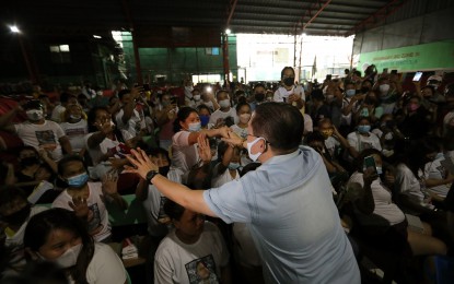 <p><strong>HIGH FIVE</strong>. Senator Christopher Lawrence "Bong" Go (right) is welcomed by kids upon his arrival at the Barangay 310 Covered Court in Sta. Cruz, Manila to visit the fire victims on Wednesday (May 18, 2022). A total of 62 families or 229 individuals were affected by the fire. <em>(PNA photo by Joey O. Razon)</em></p>