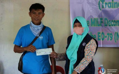 <p><strong>SKILLS, INCOME.</strong> A former combatant of the Moro Islamic Liberation Front (MILF) shows the check from the Ministry of Basic, Higher and Technical Education-Technical Education and Skills Development in the Bangsamoro Autonomous Region in Muslim Mindanao. At least 219 ex-MILF rebels graduated on Thursday (May 19, 2022) from a monthlong skills development training facilitated by the MBHTE-TESD. <em>(Photo courtesy of MBHTE-BARMM)</em></p>