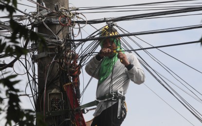 <p><strong>FIBER LINES</strong>. A lineman installs a new fiber line for PLDT in General Trias, Cavite on May 22, 2022. PLDT on Monday (July 8, 2024) announced a closer collaboration with the Metropolitan Manila Development Authority to minimize service outages caused by fiber cuts due to road works.<em> (PNA photo by Avito Dalan)</em></p>