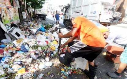 <p><strong>UNSEGREGATED</strong>. Garbage collectors have to use shovels and plastic boxes to collect unsegregated trash along Zapote Road near Caloocan City Hall Extension on May 24, 2022. Environment Acting Secretary Jim Sampulna on Monday (May 30) said solid waste management remains a major problem for the Philippines mostly due to the mismanagement of waste segregation at the local level. <em>(PNA photo by Oliver Marquez)</em></p>