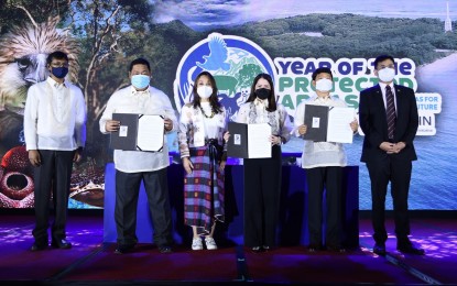 <p><strong>JOINT DECLARATION</strong>. Department of Environment and Natural Resources Acting Secretary Jim Sampulna (2nd from left), Department of Tourism Secretary Bernadette Romulo-Puyat (4th from left) and Department of the Interior and Local Government Secretary Eduardo Año (2nd from right) sign a joint declaration in celebration of the Year of the Protected Areas on Monday (May 23, 2022). They are joined on stage by Senator-elect Loren Legarda-Leviste (3rd from left), United Nations Development Program Philippines Resident Representative Dr. Selva Ramachandran (extreme left) and Climate Change Commission Secretary Robert Borje. <em>(Photo by DOT)</em></p>