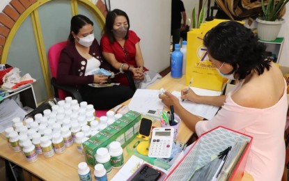 <p><strong>ARRESTED</strong>. An operative from the National Bureau of Investigation (NBI) examines the health products in front of the 17 Global officers arrested on May 20, 2022 in Quezon City over an investment scam. NBI OIC-Director Eric Distor earlier made directive to apprehend those involved in investment scam. <em>(Contributed photo)</em></p>