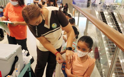 <p><strong>READY FOR F2F.</strong> Gavriella Samantha Ilagan, 9, receives her first dose of the Pfizer Covid-19 vaccine inside a mall in Dasmariñas City, Cavite on Wednesday (May 25, 2022). The mother said her child needs to be vaccinated before the possible opening of face-to-face classes in August. <em>(PNA photo by Gil Calinga)</em></p>