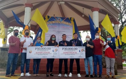 <p><strong>RECOGNITION</strong>. Negrense boxers Rogen Ladon (center) and James Palicte (4th from right), both medalists in the just concluded 31st Southeast Asian Games in Hanoi, Vietnam, receive cash incentives from their hometown Bago City in Negros Occidental during a heroes’ welcome led by Mayor Nicholas Yulo (3rd from right) on Monday (May 30, 2022). Ladon won the gold in the flyweight division while Palicte took the bronze in the lightweight class. <em>(PNA photo by Nanette L. Guadalquiver)</em></p>
