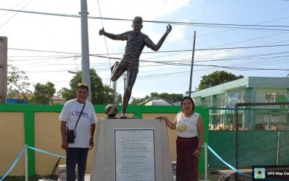 <p><strong>IN MEMORIAM</strong>. Parents of Kieth Absalon, the famed footballer of the Far Eastern University, stand in front of his monument that was unveiled on Monday (June 6, 2022) at Masbate Sports Complex in Masbate City. Absalon and his cousin were killed in a roadside explosion from an anti-personnel mine planted by the New People's Army in 2021. <em>(Photo courtesy of PRO-5)</em></p>