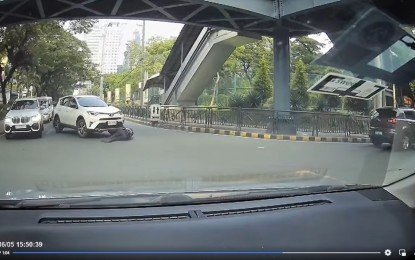 <p><strong>CRIME SCENE.</strong> Security guard-traffic enforcer Christian Floralde falls right in front of the white sports utility vehicle that bumped him at the corner of Julia Vargas Avenue and St. Francis Street in Mandaluyong City on Sunday afternoon (June 5, 2022). The vehicle then ran over him and fled. <em>(Screengrab from Mike Angelo Ramos Facebook video)</em></p>