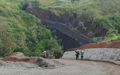 <p><strong>NEARING COMPLETION</strong>. Residents of Barangay Bulan-bulan in San Remigio, Antique pass by the remaining uncemented portion of the four-kilometer road from Barangay Aningalan on Wednesday (June 8, 2022). The road concreting project is now 70 percent completed. <em>(PNA photo by Annabel Consuelo J. Petinglay)</em></p>