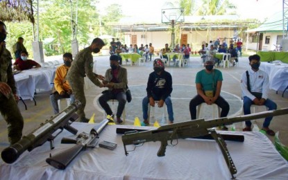 <p><strong>NEW LIFE.</strong> The five former Bangsamoro Islamic Freedom Fighters extremists (seated) and their firearms they turned over to the military after deciding to surrender on Wednesday (June 8, 2022). The group claims they operated in the peripheries of four Maguindanao towns before their surrender. <em>(Photo courtesy of Army’s 6th Infantry Division)</em></p>