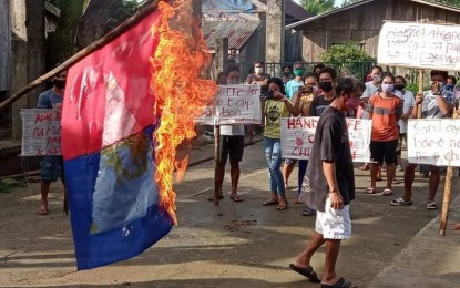 <p><strong>DENOUNCING NPA</strong>. Residents of Luisita village in Victoria, Northern Samar burn a flag of the New People's Army (NPA) during a peace rally denouncing the armed group in this Sept. 8, 2021 photo. The Philippine Army has expressed concern over the possible NPA resurgence in seven remote villages of Victoria as former rebels refuse to cooperate in the government’s counterinsurgency efforts. <em>(Photo courtesy of Victoria municipal police station)</em></p>