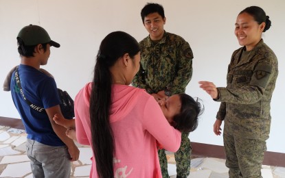 <p><strong>REUNITED</strong>. Two self-confessed members of the New People's Army in southern Negros Oriental surrender to the police and military on Friday (June 10, 2022). They were reunited with their almost two-year-old son, whom they had not seen since their separation a month after being born. <em>(Photo by Judy Flores Partlow)</em></p>