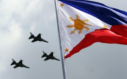 <p><strong>FLYBY PREPS.</strong> Three FA-50 jet fighters of the Philippine Air Force (PAF) soar above the Philippine flag at Rizal Park in Manila on Friday (June 10, 2022). It is part of preparation for the flyby on Sunday (June 12) in celebration of the country's 124th Independence Day.<em> (PNA photo by Joey Razon)</em></p>