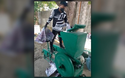 <p><strong>PLASTIC BRICKS</strong>. A worker uses a shredding machine to cut into pieces the donated posters of candidates in this undated photo in Piddig, Ilocos Norte. These shredded plastics are combined with sand to make hollow blocks for building materials. <em>(Photo by Leilanie Adriano)</em></p>