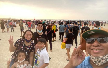 <p><strong>RELAXING DOLOMITE BEACH</strong>. Rodney Maranan (right) takes a group photo or "groufie" with his family at the reopening of the Manila Bay dolomite beach, alongside their celebration of Independence Day, on Sunday (June 12, 2022). Maranan said the rehabilitated dolomite beach is a good place for fun and relaxation. <em>(Photo courtesy: Rodney Maranan)</em></p>