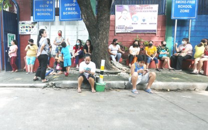 <p><strong>MOBILE PHONES</strong>. Bystanders are busy on their phones while waiting outside the Delfin Geralde Elementary School along Salvia Street in Barangay Kaligayahan Novaliches, Quezon City on Tuesday (June 15, 2022). The PLDT-Smart Communications on Monday (June 20) said over 23 million smishing text messages have been blocked by their filters from June 11 to 14. <em>(PNA photo by Oliver Marquez)</em></p>