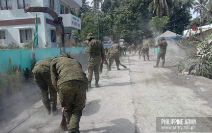 <p><strong>CLEARING OPS.</strong> Philippine Army reservists clear ashfall from roads in Barangay Rangas in Juban, Sorsogon on Tuesday (June 14, 2022). The Army and other government agencies continue to aid residents affected by Mount Bulusan’s unrest. <em>(Photo courtesy of Philippine Army)</em></p>