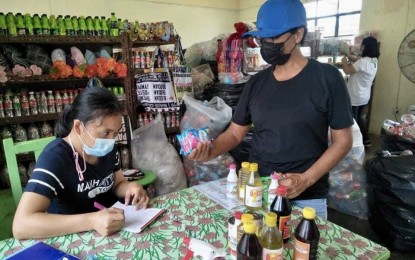 <p><strong>EXCHANGE.</strong> A villager exchanges her collected plastic waste materials for household supplies in this undated photo at the Basura Exchange School Tiangge located at Burgos Central Elementary School. The store is open every Tuesday and Thursday. <em>(Contributed photo)</em></p>