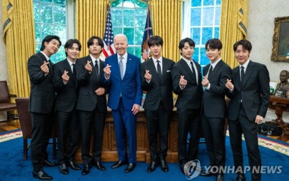 <p>The members of K-pop sensation BTS make hearts with their fingers while posing for photos with US President Joe Biden during their talks on anti-Asian hate crimes at the White House in Washington on May 31, 2022, in this photo provided by Big Hit Music. <em>(Yonhap photo)</em></p>