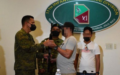 <p><strong>NOTORIOUS BANDITS.</strong> Two 'notorious' members of the Abu Sayyaf Group surrender to the Joint Task Force (JTF)-Sulu Friday (June 17, 2022). One of the two surrenderers says they decided to lay down their arms as they no longer have the support of their former strongholds in the island-province.  <em>(Photo courtesy of JTF-Sulu)</em></p>