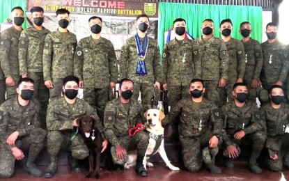 <p><strong>AWARDEES</strong>. Maj. Gen. Benedict Arevalo (center), commander of the Army’s 3rd Infantry Division, with the troops and military working dogs of the 15th Infantry Battalion who received the Military Merit Medal for successful operations against the CPP-NPA in Candoni, Negros Occidental on May 3, 2022. The awarding rites were held on Friday (June 17) at the battalion headquarters in Barangay Tiling, Cauayan town in southern Negros.<em> (Photo courtesy of 3rd Infantry Division, Philippine Army)</em></p>