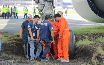 <p><strong>PREPARING TO TOW</strong>. Personnel at the Ninoy Aquino International Airport prepare to tow an aircraft that veered off the grassy portion of the taxiway on Monday (June 20, 2022). All passengers and crew of Saudia Airlines flight SV862 are safe, according to authorities.<em> (Photo courtesy of Manila International Airport Authority)</em></p>
