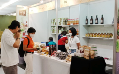 <p><strong>FEATURED PRODUCTS.</strong> Various homegrown food products of the Davao Region are presented at the National Food Fair in Manila on June 1-5, 2022. During a visit, Steep Pro Philippines, Inc. Manager May Mae Cueva (center in photo) inquires about the production capacity of the Maragusan Multipurpose Cooperative for the 'tablea' or cocoa bean tablet, as her company needs 500 kilograms per month.<em> (Photo courtesy of DTI-11)</em></p>