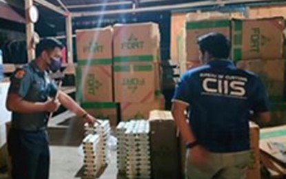 <p><strong>CIGARETTES SHIPMENT.</strong> A police officer and a Bureau of Customs personnel conduct inventory on the smuggled cigarettes seized Tuesday (June 21, 2022) near Manalipa Island, Zamboanga City. The joint police and BOC operatives were on maritime patrol when they intercepted a motorboat loaded with some P9.6 million worth of smuggled cigarettes. <em>(Photo courtesy of Area Police Command-Western Mindanao)</em></p>