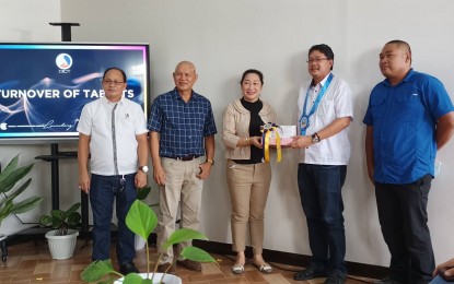 <p><strong>VAX DATA</strong>. Lambunao Vice Mayor Arvin Losaria (second from right) receives a set of computer tablets with keyboards from DICT Western Visayas Regional Director Jane Javellana (3rd from left) during the turnover ceremony held at the Digital Transformation Center in Passi City on Wednesday (June 22, 2022). The tablets would help local government units with the encoding of their vaccination status. <em>(PNA photo by Perla G. Lena) </em></p>