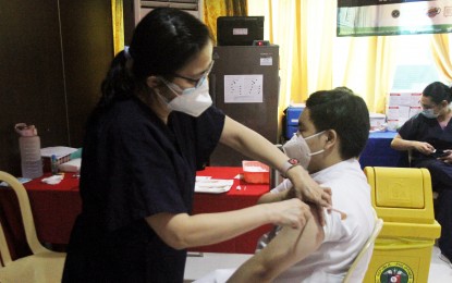 <p>A schoolboy gets vaccinated against the coronavirus. <em>(PNA photo by Rico Borja)</em></p>