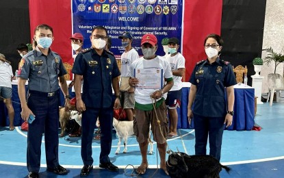 <p><strong>PEACE COVENANT</strong>. A farmer-beneficiary receives a goat from the government during the signing of a peace covenant to promote peace and order in the country on Sunday (June 26, 2022) in Currimao, Ilocos Norte. At least 105 members of the Alyansa Dagiti Mannalon iti Ilocos Norte signed the covenant. <em>(Contributed)</em></p>