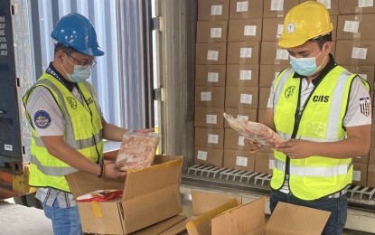 <p><strong>SMUGGLED.</strong> Officers of the Customs Intelligence and Investigation Service (CIIS) inspect smuggled frozen pork and poultry products at the Manila International Container Port (MICP) on Monday (June 27, 2022). The shipments worth PHP85 million were initially declared as containing hotpot balls and steamed buns.<em> (Photo courtesy of BOC-MICP)</em></p>