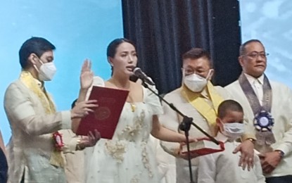 <p><strong>FIRST FEMALE MAYOR.</strong> Newly-elected Mayor of Bayambang town, Pangasinan, Mary Clare Judith Phyllis “Niña” Jose- Quiambao (second from left), takes her oath on June 28, 2022. She was accompanied by her husband, incumbent Mayor Cezar Quiambao (third from left). <em>(Photo by Hilda Austria)</em></p>
