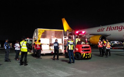 <p><strong>LIFE-SAVING JABS.</strong> An Air Hongkong flight lands with 299,520 doses of the Pfizer Covid-19 vaccine for 12 years old and above at Ninoy Aquino International Airport Terminal 3 on Monday night (June 27, 2022). The jabs were donations from the United States through the COVAX Facility. <em>(PNA photo by Lade Kabagani)</em></p>