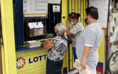 <p>Bettors try their luck in winning millions by placing their bets at this Lotto outlet. <em>(File photo)</em></p>